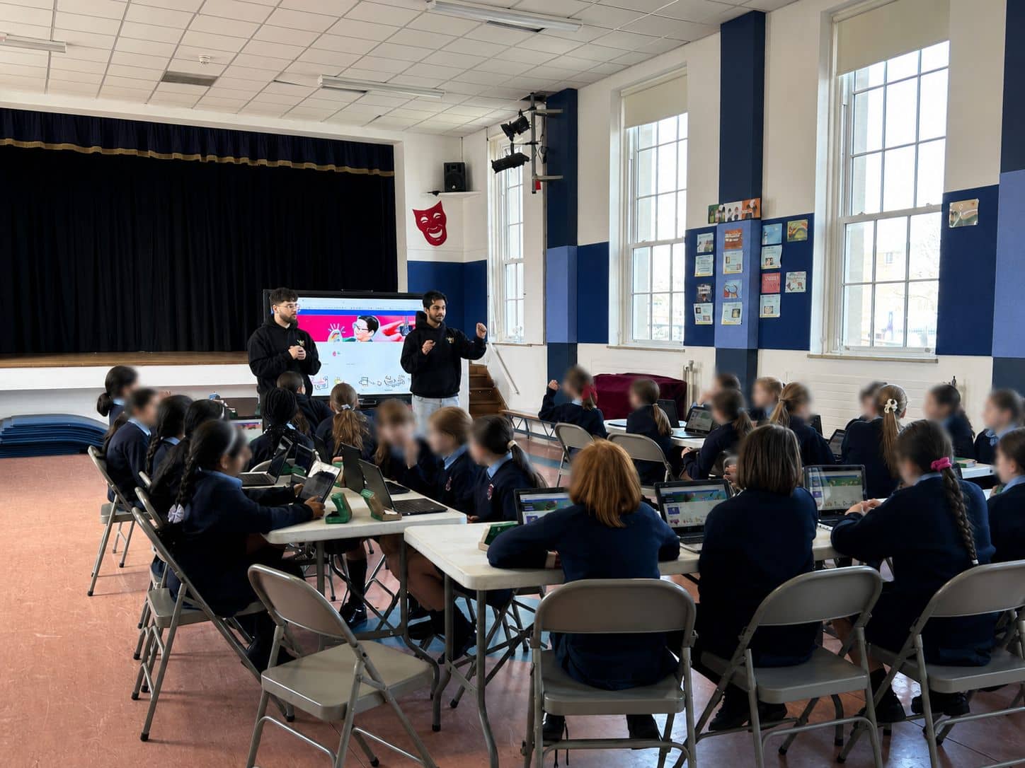 YoungMinds mentors delivering an interactive coding lesson to a full classroom